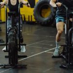 Two people exercising on stationary bikes at a modern gym.